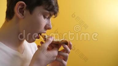 披萨。 快乐的青少年男孩吃一片披萨的概念。 十几岁的男孩饿了，吃一片比萨饼的生活方式。 慢动作